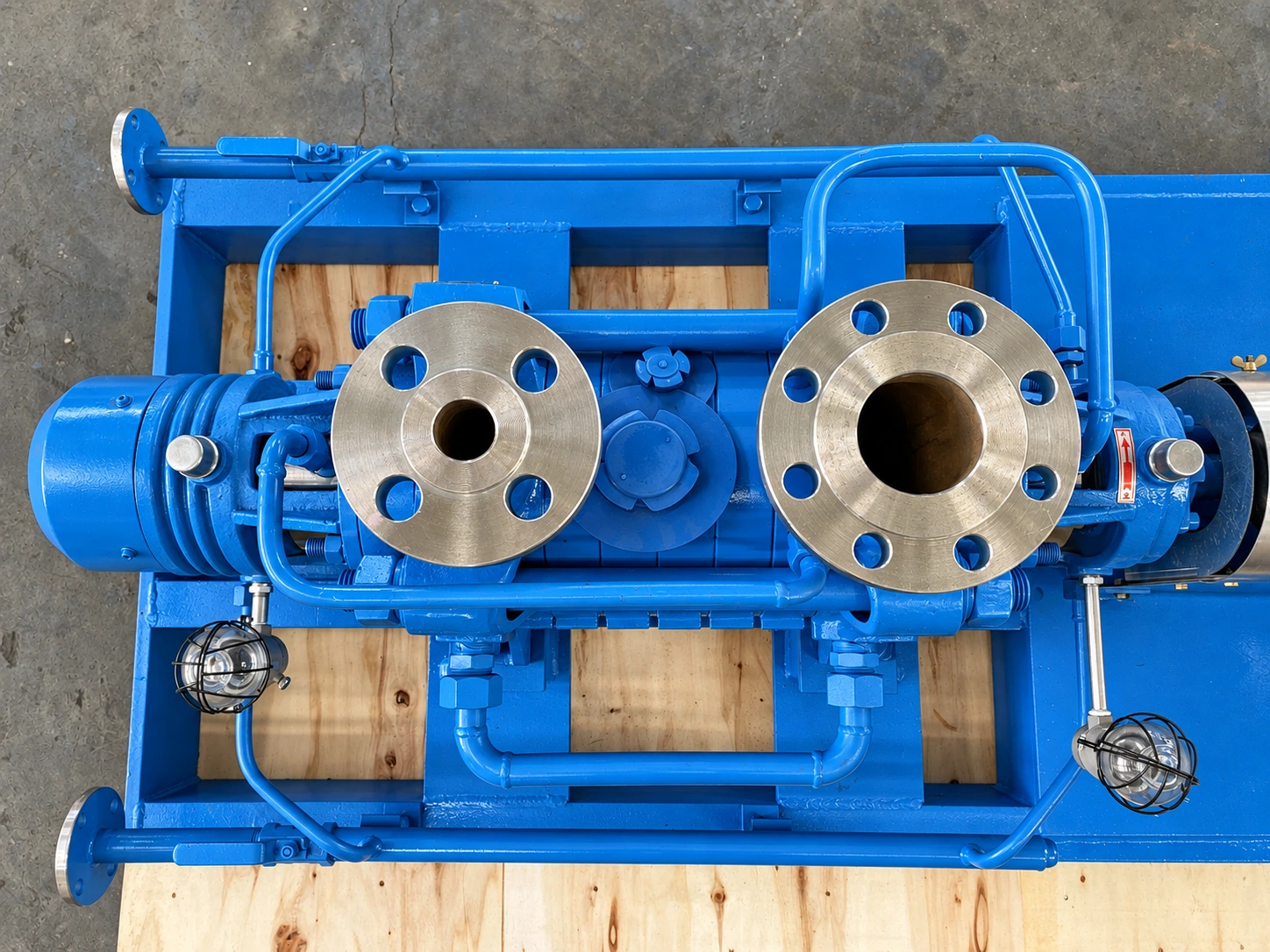 Top view of a blue pump and its two flanged connections.