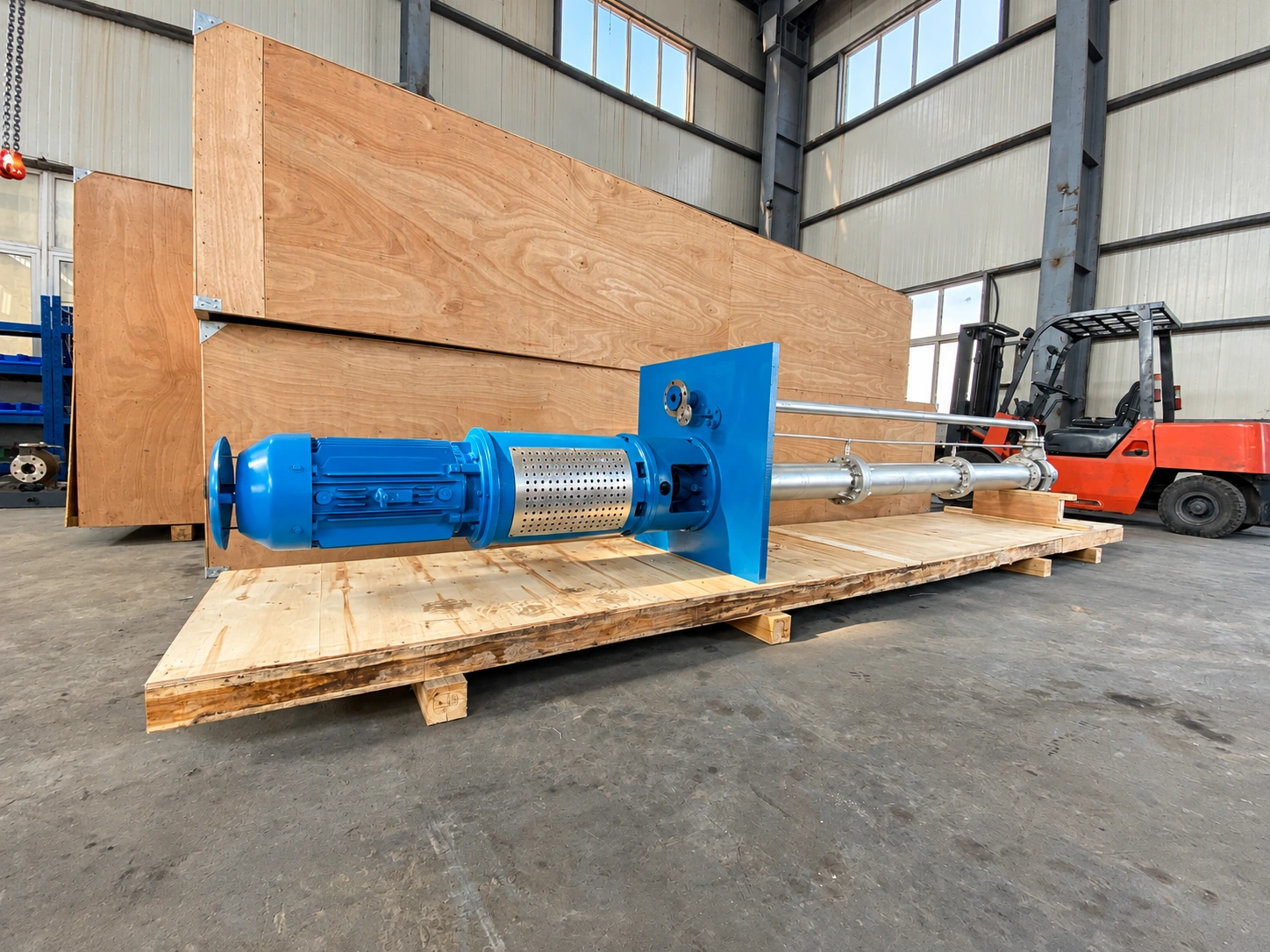 Blue long-column pump laid horizontally on a wooden pallet.